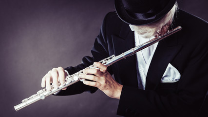 Elegantly dressed male musician playing flute © anetlanda