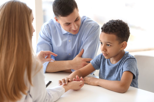 Pediatrician examining African-American boy in clinic