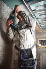 Workman plastering gypsum walls inside the house.