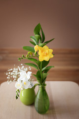 Vases with beautiful flowers on table