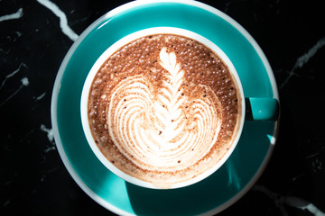 Coffee cup with latte art foam on wood table in coffee shop with copy space.Coffee is one of the most popular beverages.Improve Energy Levels and Burn Fat