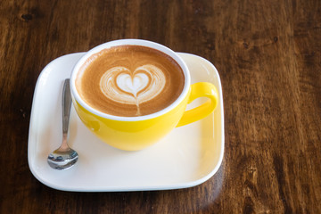 Coffee cup with latte art foam on wood table in coffee shop with copy space.Coffee is one of the most popular beverages.Improve Energy Levels and Burn Fat