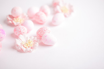 Pink Easter eggs and flowers on white background