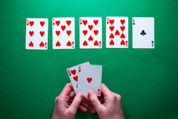 Player at the table playing and showing cards at poker game. Winning combination. Gambling addiction. Texas holdem