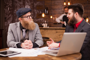 Handsome bearded coworkers having a conversation in a coffee shop
