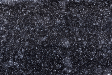 Lots of flying snowflakes on a dark background