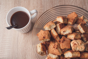 White cup of cocoa and cookies with cinnamon. Background with sweet breakfast on table