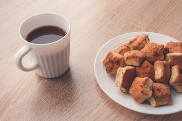 Cookies with cinnamon on plate on light wooden background