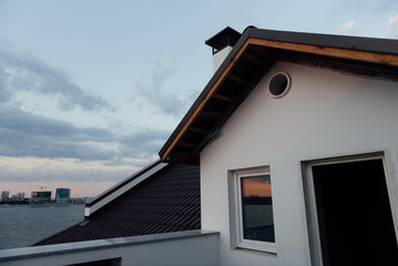 Tile Roof of a two-story white cottage