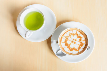 hot cappuccino coffee with green tea on table