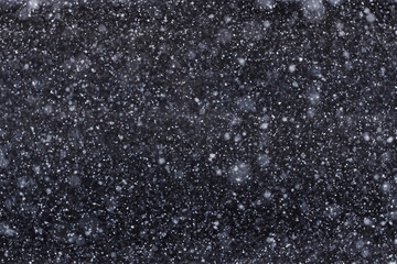 White spots on a black background, falling snow at night, snowfall