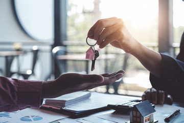 Real estate agents agree to buy a home and give keys to clients at their agency's offices. Concept agreement