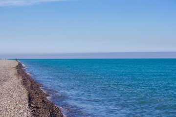 Waves in the sea. Blue sea, sea coast, small stones.