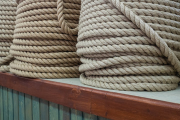 Fototapeta na wymiar A large number of the twisted ropes in a roll. Ropes on a counter of shop. Sale of various ropes