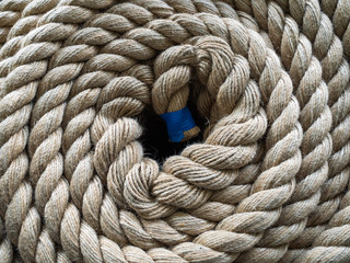 The thick rope twisted in a roll. The top view on a rope spiral. The rope curtailed into a circle