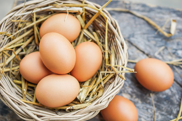 chicken eggs in basket on wooden table closeup 