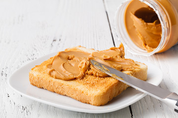 Breakfast with toasted bread and peanut butter on table