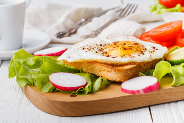crispy toast with a fried egg and fresh arugula, a cup of coffee, breakfast in hotel room