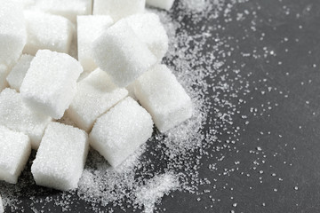 White sugar cubes over black background close up