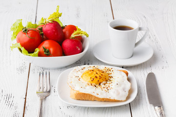 crispy toast with a fried egg and fresh arugula, a cup of coffee, breakfast in hotel room