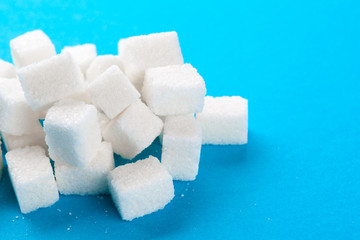 White sugar cubes on a bright blue background