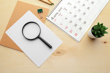 Obraz na płótnie Canvas Concept image of business and meetings. Calendar to remind you an important appointment and Magnifying glass