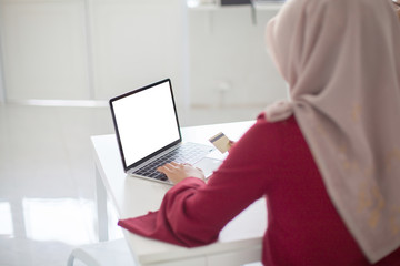 Young beautiful asian Muslim woman working with computer Tablet blank screen and calculator