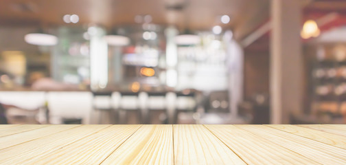 Wood table top with Cafe Restaurant interior with bar counter blur abstract background with bokeh light