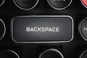 A close-up or macro shot of the rectangular BACKSPACE key of a black antique style typewriter keyboard in horizontal image format.