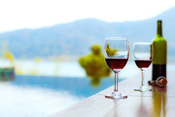Two glasses of red wine near the swimming pool with a spectacular view of the sea