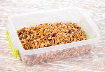 granola with berries in plastic container