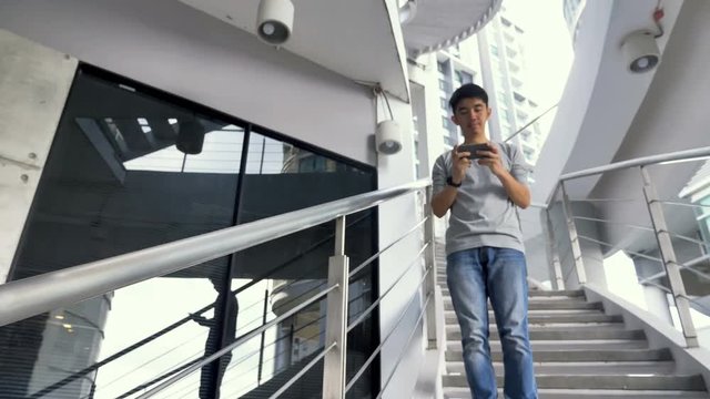4K Clumsy Asian man  falling down from stairs, Accident by using smartphone