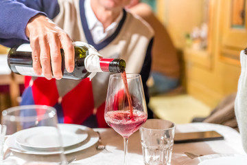 man pours red wine
