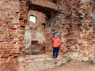 little boy alone on the ruins of an old castle.