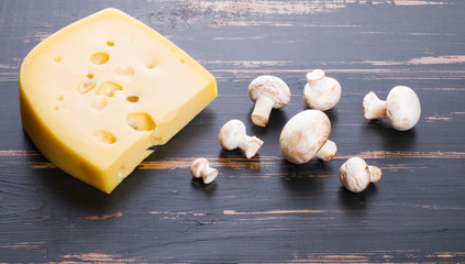 on wooden background cheese and mushrooms
