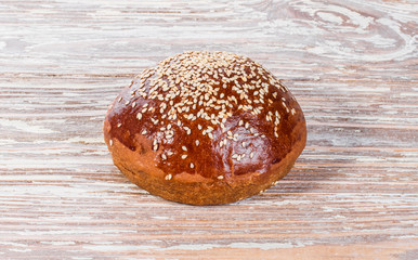 bun with sesame seeds on wooden background