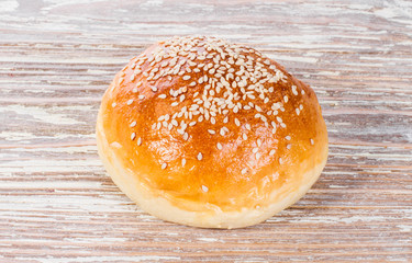 bun with sesame seeds on wooden background