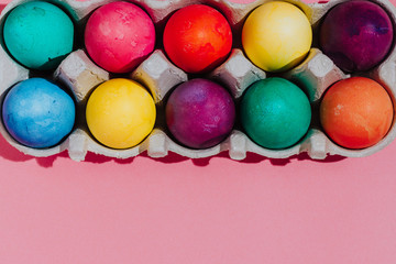 Easter background with Easter eggs. Top view with copy space. multicolored Easter eggs on a pink background