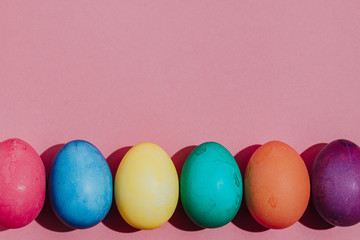 Easter background with Easter eggs. Top view with copy space. multicolored Easter eggs on a pink background