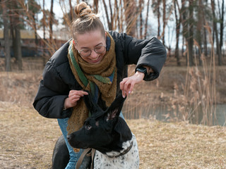 girl walking a big blind dog in the spring