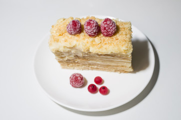 cake with raspberries and currants on a plate