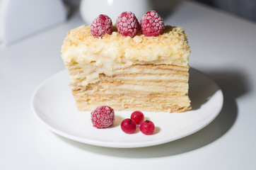 cake with raspberries and currants on a plate