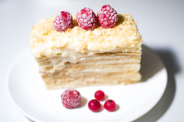 cake with raspberries and currants on a plate