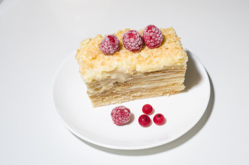 cake with raspberries and currants on a plate