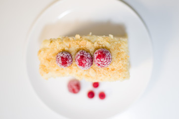 cake with raspberries and currants on a plate
