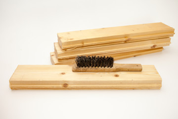 Hand wire brush on wooden pine Board. Aging wooden boards by brushing. White background.