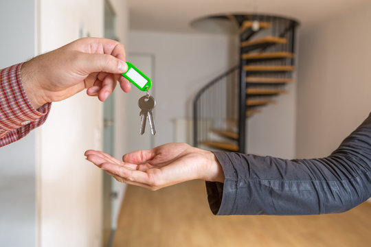 Der Wohnungsschl&uuml;ssel wird &uuml;bergeben, im Hintergrund ist eine leere Maisonette Wohnung zu sehen