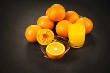 oranges on dark with juicer