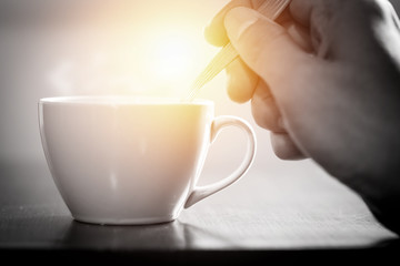One using spoon mixing hot coffee in the morning