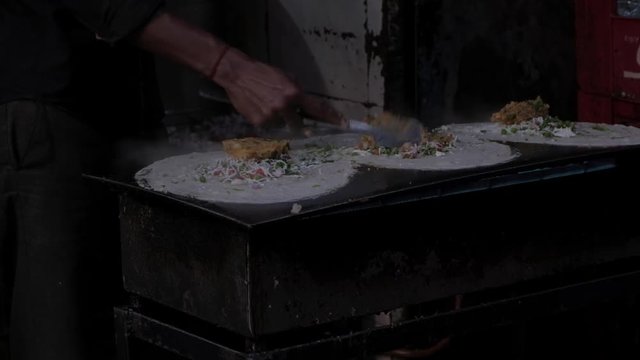 Opening cooking of Indian street food of aloo chaat and dosa being made in the city of Varanasi 